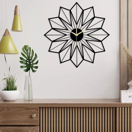 Geometric wall clock on a white wall with a wooden cabinet and plants below.